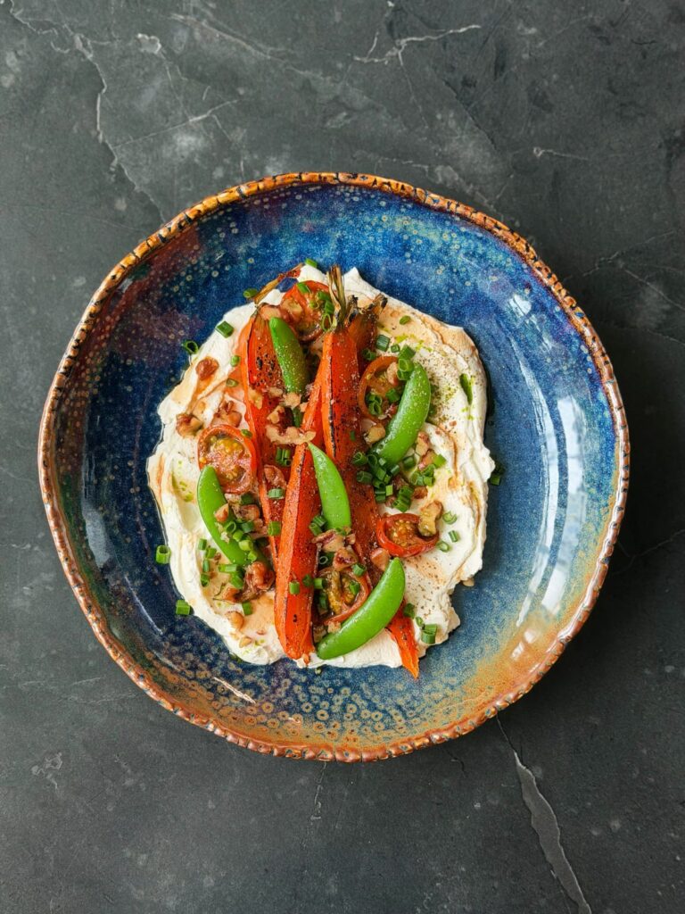 Pieczone marchewki z groszkiem cukrowym na kremowym serku